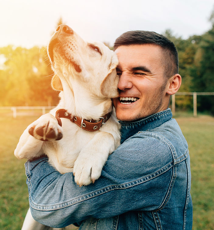 man holding dog and hugging
